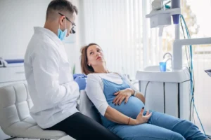 Gestante em consulta com o dentista, tratando cárie durante a gravidez